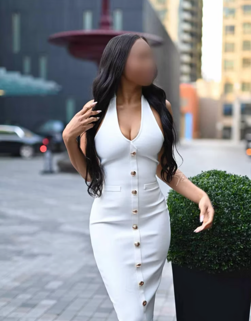 Tiana Starr elegantly dressed in a fitted white dress